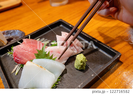 箸で持ち上げた刺身 122716582