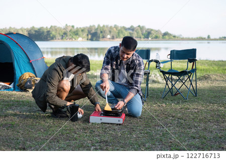 Asian homosexual couple spending their free time on holiday Camp to relax, cook and enjoy the outdoors together. Asian homosexual couple spending their free time on holiday Camp to relax, cook and enjoy the outdoors together. 122716713