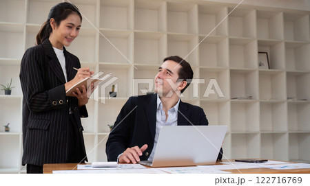 Two businessmen discussing project at the office room Businessman discusses project planning with colleagues in modern workplace while having discussion and advice on financial data report. 122716769