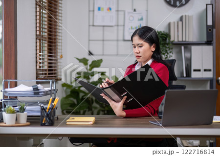 A determined businesswoman is sitting with stress in her home office. 122716814