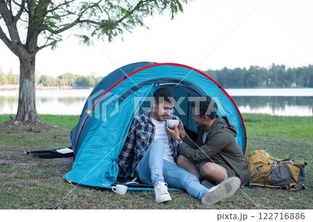 Asian homosexual couple spending their free time on holiday Camp to relax, cook and enjoy the outdoors together. Asian homosexual couple spending their free time on holiday Camp to relax, cook and enjoy the outdoors together. 122716886
