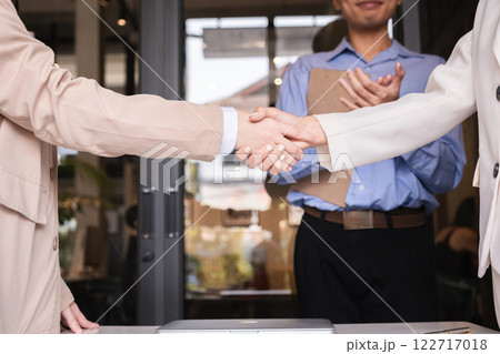 Successful negotiation, handshake, two businessmen shaking hands with partners to celebrate successful completion of deal 122717018