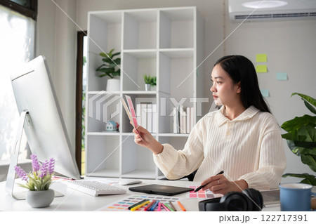 Female designer working in graphic design Choose colors for working on tablets and computer designs. Female designer working in graphic design Choose colors for working on tablets and computer designs. 122717391
