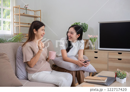 Mother and teenage daughter sitting together in the living room on vacation. Mother and teenage daughter sitting together in the living room on vacation. 122717420