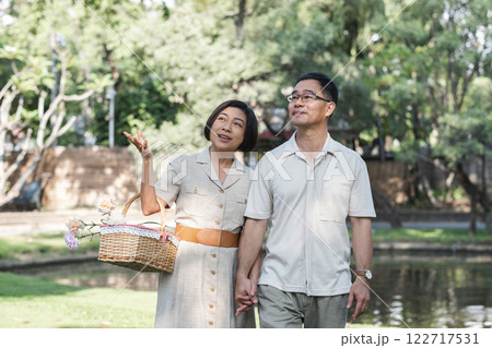 A retired couple walks outside together in the park on a relaxing vacation. 122717531