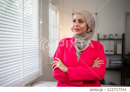 Confident Muslim businesswoman supervisor checks work on holiday and works in home office Confident Muslim businesswoman supervisor checks work on holiday and works in home office 122717541