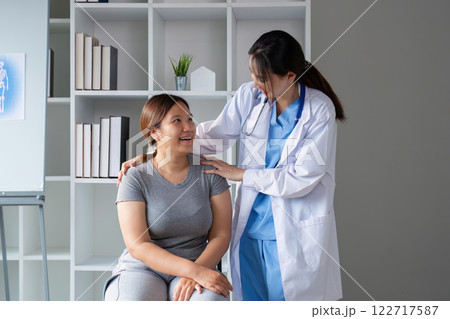 Female doctor and elderly female patient consulting about health problems in clinic 122717587