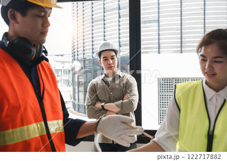 Handsome young chief engineer standing during engineer team discussion at construction site 122717882