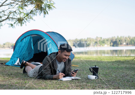 Asian tourists spend their free time camping, relaxing, and reading books. and happily doing outdoor activities 122717996