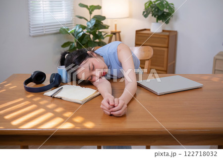 Asian college student who is bored Sitting in front of a laptop studying online through a video calling program on a laptop at home. Asian college student who is bored Sitting in front of a laptop studying online through a video calling program on a laptop at home. 122718032