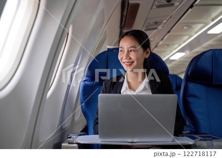 A young business woman travels to work outside the city by flying in business class. and work on airplanes with laptops 122718117