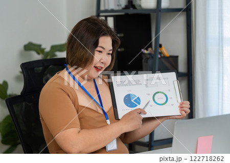 Young Businesswoman Conducting Online Meeting with Financial Graphs Displayed on Screen for Remote Presentation and Analysis Young Businesswoman Conducting Online Meeting with Financial Graphs Displayed on Screen for Remote Presentation and Analysis 122718262