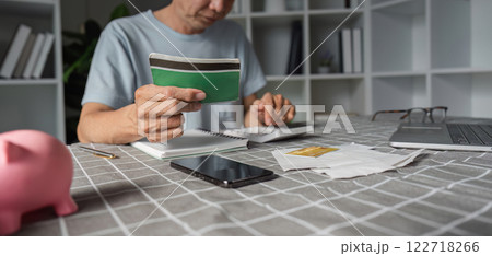 Elderly man analyzing savings with a calculator and wallet at his home office 122718266