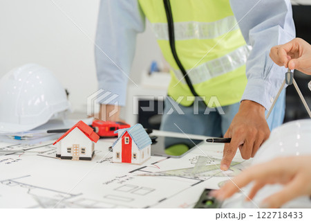 Architectural team discussing building designs with scale models during a planning session 122718433
