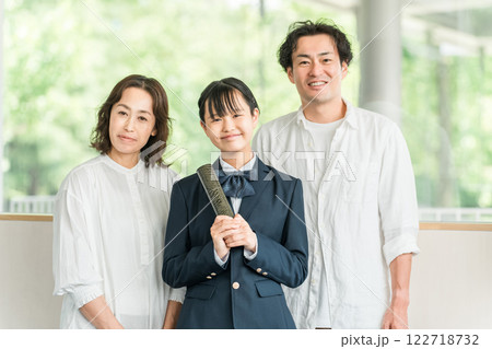 卒業証書を持つ中学生の女の子と両親 卒業証書を持つ中学生の女の子と両親 122718732