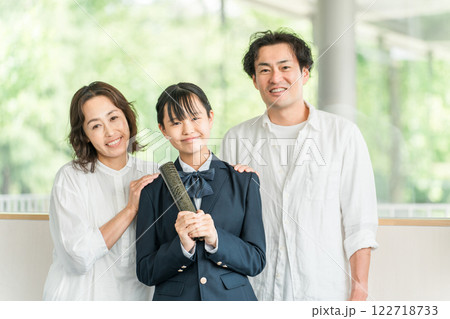 卒業証書を持つ中学生の女の子と両親 卒業証書を持つ中学生の女の子と両親 122718733