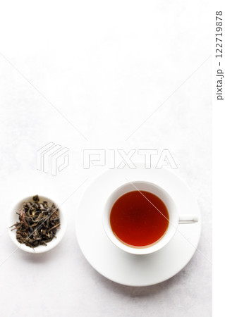 Cup of hot tea with tea leaf on white table background. Cup of hot tea with tea leaf on white table background. 122719878