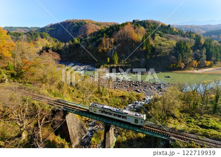 晩秋の信州栄村 千曲川沿い栄大橋から望む鉄橋を渡るJR飯山線のローカル列車 122719939