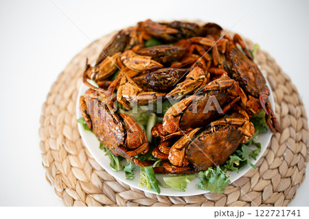 Delicious spicy whole roasted crabs on woven mat background 122721741