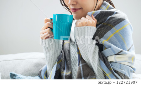 寒い部屋でホットドリンクを飲む女性 寒い部屋でホットドリンクを飲む女性 122721907