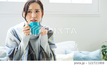 寒い部屋でホットドリンクを飲む女性 寒い部屋でホットドリンクを飲む女性 122721908