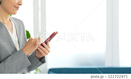 オフィスでスマホを使う女性ビジネスパーソン オフィスでスマホを使う女性ビジネスパーソン 122722971