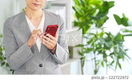 オフィスでスマホを使う女性ビジネスパーソン オフィスでスマホを使う女性ビジネスパーソン 122722972