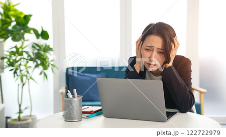 オフィスでノートパソコンを見て悩む女性ビジネスパーソン オフィスでノートパソコンを見て悩む女性ビジネスパーソン 122722979