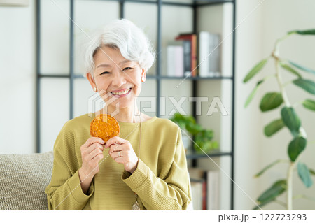 せんべいを食べるシニアの女性 122723293