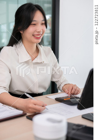 Young woman calculates stock value using calculator Young woman calculates stock value using calculator 122723811