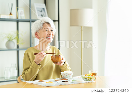 朝食で味噌汁を飲むシニアの女性 122724840