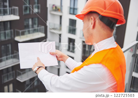 Young architect wearing a protective helmet standing on the mountains building outdoor background 122725503