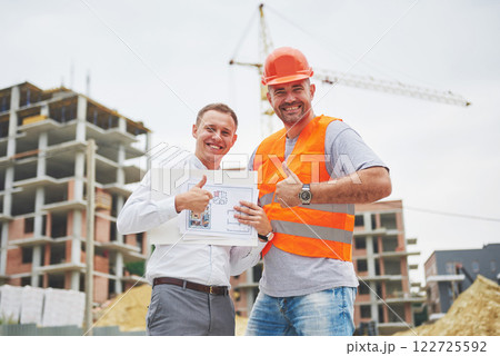 construction, architecture, business, teamwork and people concept - happy architects with blueprint at building site construction, architecture, business, teamwork and people concept - happy architects with blueprint at building site 122725592