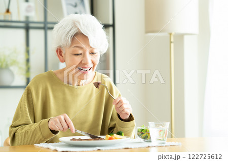 ステーキを食べるシニアの女性 ステーキを食べるシニアの女性 122725612