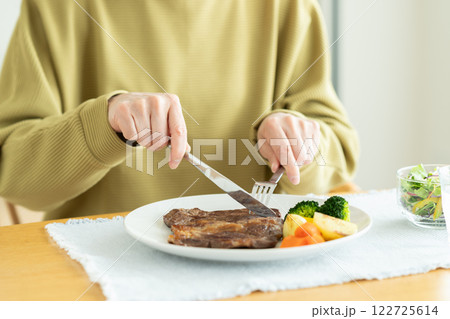 ステーキを食べるシニアの女性 122725614