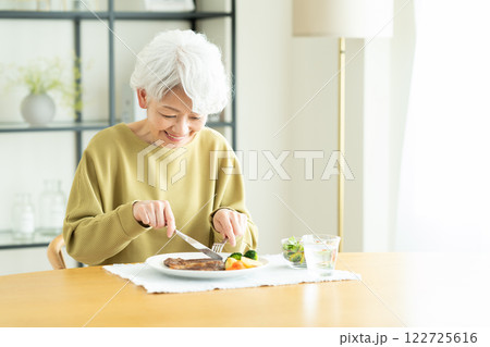 ステーキを食べるシニアの女性 ステーキを食べるシニアの女性 122725616