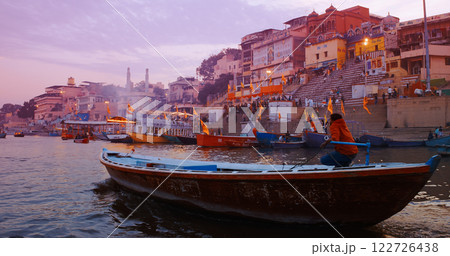 Varanasi, Uttar Pradesh, India. Many Boats moored on Ganga river near ghats. Hundreds of tourists and locals come in boats to watch Ganga Maha Aarti ceremony and the fire ceremony. Purple sunset sky Varanasi, Uttar Pradesh, India. Many Boats moored on Ganga river near ghats. Hundreds of tourists and locals come in boats to watch Ganga Maha Aarti ceremony and the fire ceremony. Purple sunset sky 122726438