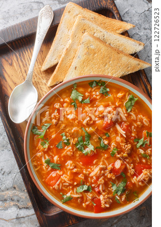 Bowl of delicious stuffed pepper soup served with toasts closeup. Vertical top view Bowl of delicious stuffed pepper soup served with toasts closeup. Vertical top view 122726523