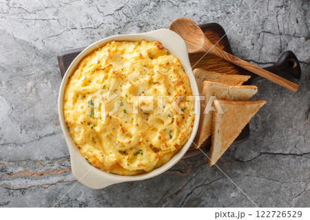 Fluffy delicious baked mashed potatoes with cheese, cream and butter close-up in baking dish. Horizontal top view 122726529