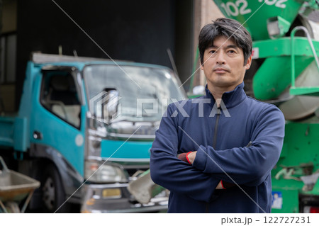 ミキサー車の前に立つ男性 122727231