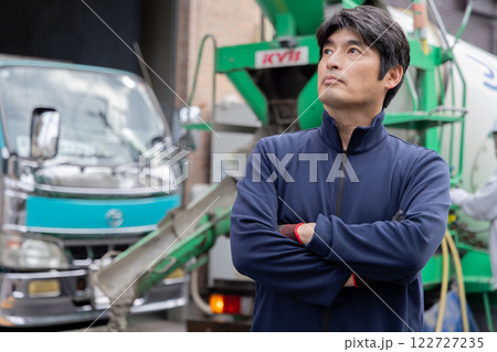 ミキサー車の前に立つ男性 122727235