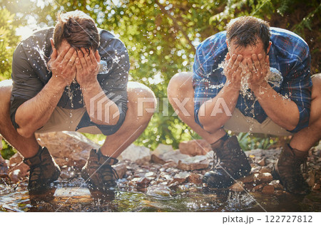 Hiking men splash face with water for cool, relax and cleaning dirt when trekking on rock or hike in countryside forest. Earth, freedom after camping in nature and travel along mountain river or lake 122727812