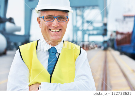 Happy cargo, logistics and shipping manager smile on a port with a factory, warehouse or plant in the background. Manufacturing, supply chain and freight leader in the industrial delivery business Happy cargo, logistics and shipping manager smile on a port with a factory, warehouse or plant in the background. Manufacturing, supply chain and freight leader in the industrial delivery business 122728623
