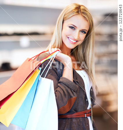 Shopping, retail and customer with a woman in a store, mall or shop with bags and spending money on fashion. Sale, beauty and consumerism with a young consumer in a boutique or clothing outlet 122728643