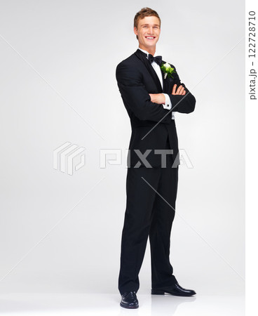 Wedding, marriage and groom with a handsome man standing arms crossed in studio against a white background. Happy male in a suit or tuxedo with a smile ready to get married at a celebration event Wedding, marriage and groom with a handsome man standing arms crossed in studio against a white background. Happy male in a suit or tuxedo with a smile ready to get married at a celebration event 122728710