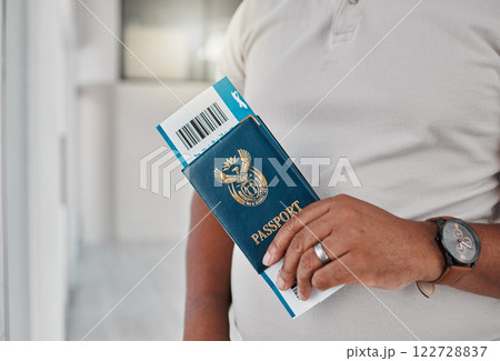 Man at airport with passport, travel visa and ticket for plane flight of international immigration. Hands of tourist, traveller and passenger waiting for airplane departure with identity documents Man at airport with passport, travel visa and ticket for plane flight of international immigration. Hands of tourist, traveller and passenger waiting for airplane departure with identity documents 122728837
