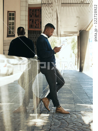 Networking, phone call and businessman in city reading email, schedule agenda or social media. Manager employee working, thinking or texting online while standing outside the office building 122728922