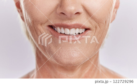 Happy woman with teeth and smile, showing her natural looking dental veneers posing against a purple mockup studio background. Model woman happy with her oral healthcare hygiene and health skincare 122729296
