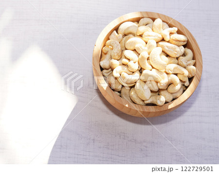 Cashew nuts in wooden bowl on white table with sunshine. Healthy food. 122729501