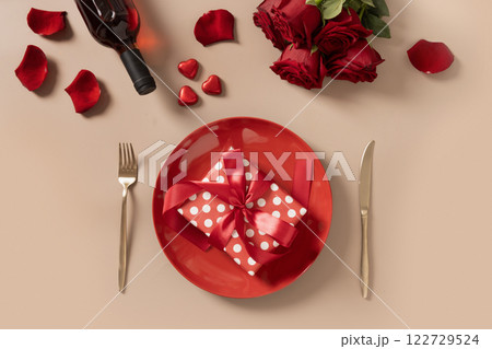 Valentine's day dinner with red plate, romantic gift and red roses. Valentine's day dinner with red plate, romantic gift and red roses. 122729524